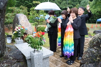 千羽鶴を手に慰霊碑の前で祈りをささげる（手前右から）江藤領さんと新潟京子さんら＝26日午前10時20分ごろ、王滝村