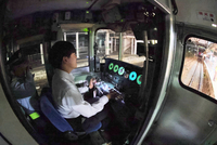 小諸駅の本線上で「115系」の運転席に座り、講師から説明を受ける参加者