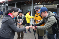 活火山の安全登山を啓発する手作りのキーホルダーを渡すシャーロックさん（左）