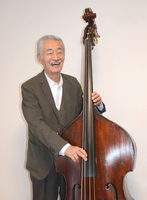 ベースを手にする鈴木さん。深く温かな音色を生み出す「脱力」の大切さも、スタープレーヤーたちとの共演で感じてきたという＝2024年2月