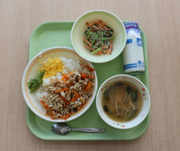 売木小中学校で提供された島根県の郷土料理「すもじ」（左）や「磯香和え」（上）が並ぶ給食