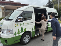 出発式後、かる～もの車両を見学する関係者