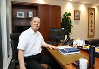 綿半ホールディングス東京本社のデスクで話す野原莞爾さん＝東京都新宿区四谷
