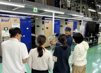 信毎の長野印刷センターで説明を受けるインターンの学生たち（手前の4人）