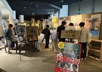 「諏訪のロケ地レビュー展」の展示に見入る観光客ら＝9月21日