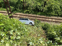 飯山線の線路敷地内に転落した軽乗用車＝8月31日、栄村（JR東日本長野事業本部提供）