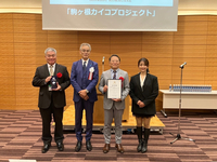 都内で開かれた表彰式で、表彰状を手にする伊藤市長（右から2人目）＝駒ケ根市提供