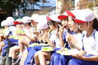 横並びになって収穫したレタスを試食する児童たち