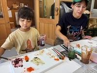 すりつぶした野菜や果物で思い思いに描く参加者