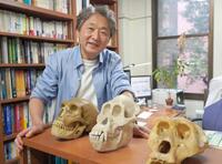 　ネアンデルタール人やサルなどの頭骨模型と太田博樹さん