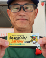 参加者に配るステッカーを手に催しをPRする村上さん