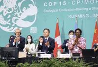 生物多様性条約第15回締約国会議で新たな生態系保全目標を採択し、拍手する出席者。ネーチャーポジティブの考えが盛り込まれた＝2022年12月、カナダ・モントリオールの国際会議場（共同）