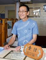 　笑顔で旅人を迎える支配人の藤当満さん＝北海道室蘭市
