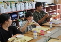 生産者と一緒に給食を食べる牟礼小学校の児童ら＝14日、飯綱町黒川
