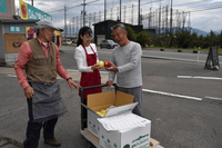 浅田さん（右）にリンゴを託す滝沢さん（左）と裕花さん