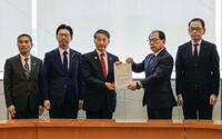 　プルサーマル発電を巡り、中国電力の三村秀行副社長（右から2人目）に意見書を提出する鳥取県の平井伸治知事（中央）ら＝14日午後、鳥取県米子市