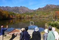 紅葉が見頃を迎え、多くの人でにぎわう鏡池＝16日午前10時9分、長野市戸隠