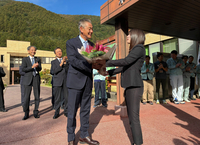 役場玄関で花束を受け取る奥原村長（手前左）