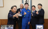 油井さん（中央）を囲んで写真撮影する柳田市長（右から2人目）や同級生ら