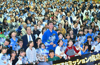 油井さん（中央）と記念写真に納まる報告会の参加者たち