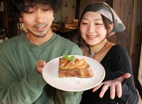 りんごのオープンサンド（中央）を見せる中嶋彩花さん夫婦＝19日、飯綱町牟礼
