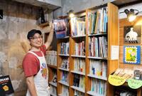 　古書を手に取る「KAIDO」店主の佐藤亮太さん＝東京都品川区
