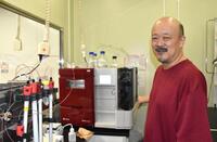 　人工細胞の材料になるタンパク質を精製する装置の前に立つ木賀大介・早稲田大教授