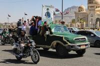 　親イラン武装組織フーシ派関係者の葬列で、車に乗る人たち＝17日、イエメン・サヌア（AP＝共同）
