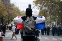 　警官隊の前でフランス国旗を掲げるデモ参加者＝13日、パリ（共同）