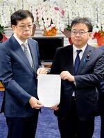 　上野厚労相（右）に「異常分娩」の用語に関する報告書を手渡す日本産科婦人科学会の関沢明彦副理事長＝20日午前、東京都千代田区