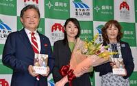 盛岡市役所で内舘茂市長(左)から市民栄誉賞を贈られ、記念写真に納まる小砂川チトさん(中央)=20日午後