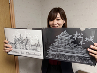 限定販売されるクリアファイル。白い紙を挟むとシャンボール城が浮かび上がる（左）