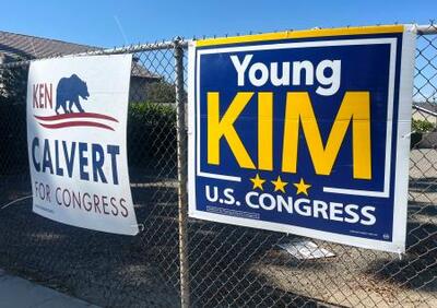 米カリフォルニア州の連邦下院第40選挙区の議席を争うヤング・キム議員の看板(右)とケン・カルバート議員の看板=8日、カリフォルニア州(共同)