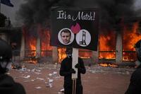 　フランス南部リヨンで、ギロチンとマクロン大統領の写真を掲げるデモ参加者＝17日（AP＝共同）